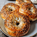 Baked cottage cheese protein bagels topped with sesame and poppy seeds on a plate