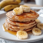 Fluffy banana and protein pancakes topped with berries and honey